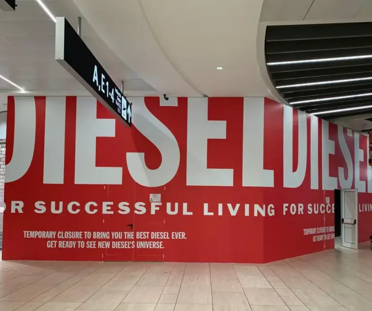 Per Diesel, marchio iconico del fashion internazionale, abbiamo realizzato la decorazione integrale delle superfici esterne del punto vendita durante il restyling del negozio. L’intervento ha previsto la copertura temporanea con grafiche personalizzate, sviluppate per mantenere alta la visibilità del brand anche durante i lavori, trasformando l’area in uno spazio di comunicazione immediatamente riconoscibile. Un progetto che unisce tecnica, precisione e creatività, con l’obiettivo di valorizzare il marchio anche nelle fasi di transizione.
